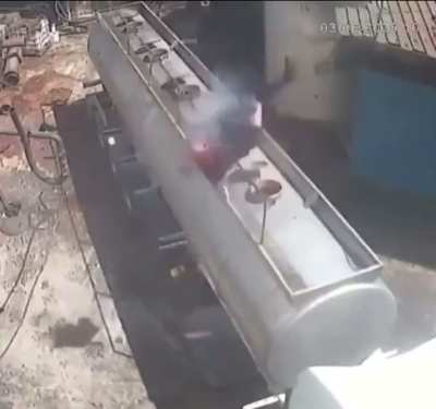 Vehicular Video - Man Sent Flying By Explosion After Opening Oil Tanker Lid While Smoking Cigarette