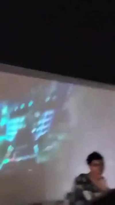 playing guitar hero projected on a moving semi