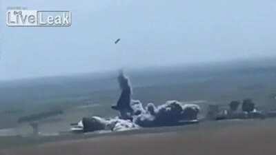 A suspected suicide car bomber runs over an IED and is launched into the air.