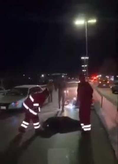 While news reporter is on a live stream reporting a car accident, a guy on a motorcycle crashes into that car on the road.