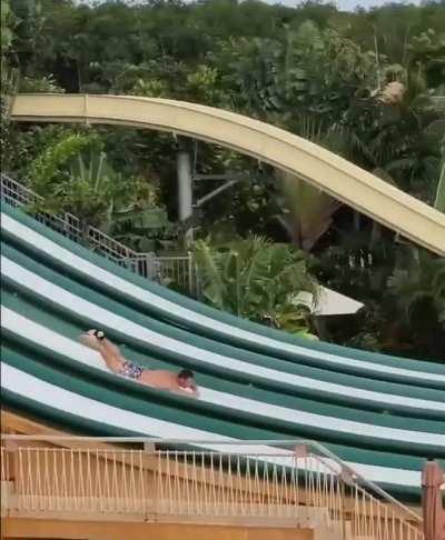 Man descends waterslide headfirst, executes impressive flip & dive