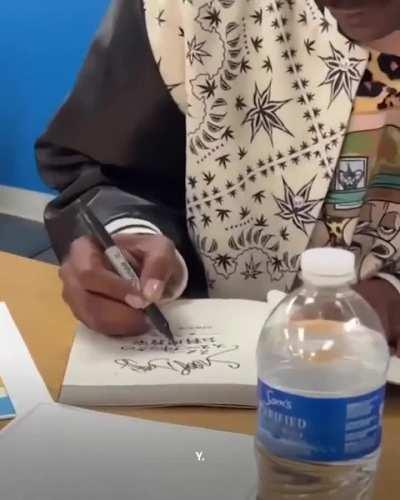 Snoop Dogg signing his autograph, in Japanese, at a Walmart