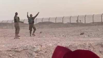 Israeli and Egyptian soldiers dance with each other over the border fence
