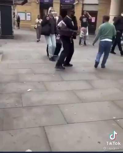 Black man aggressively booty shakes at asian man fleeing in fear and confusion