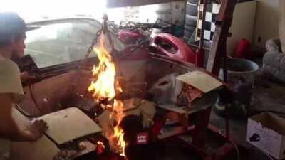Blowing on a car engine fire like it's a birthday candle.