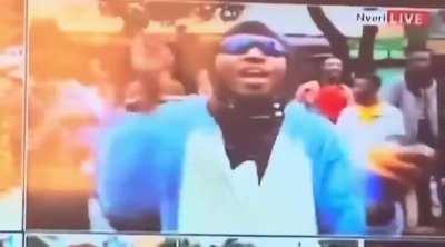 Kenyan protester smoking tear gas thrown at him by anti riot police