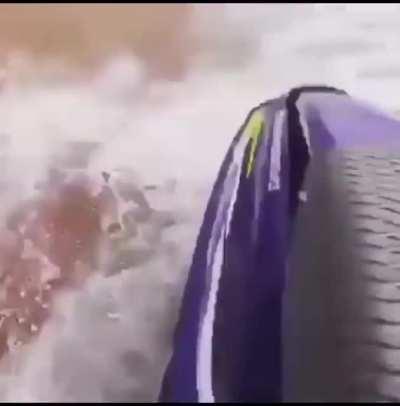 Riding a jetski next to a cargo ship