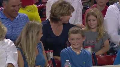 Boy hands souvenir over to girl behind him