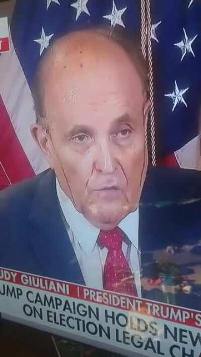 Rudy Giuliani, live right now. WTF is leaking down the sides of his face?!