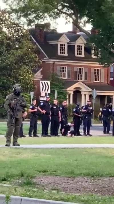 Police officer in Richmond, VA spits on and near a detained protester multiple times, during a pandemic.