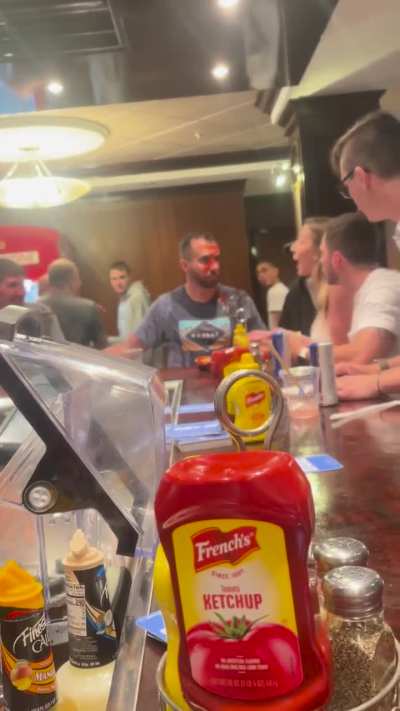 Woman squirts ketchup on two men during Norwegian Cruise bar argument