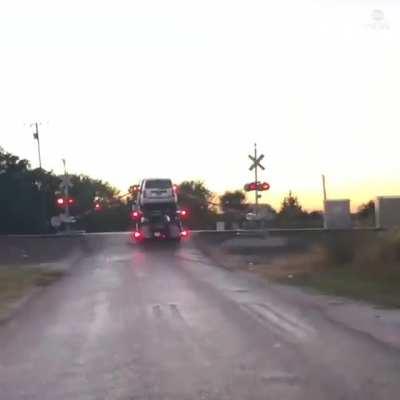 Idiot tries to drive over train tracks and bottoms out