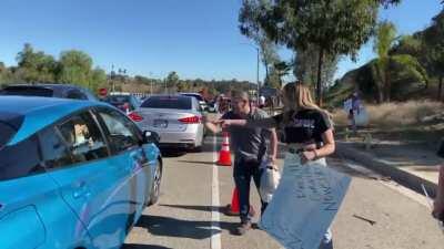 Anti-maskers mock people waiting to get vaccinated at Dodger stadium.