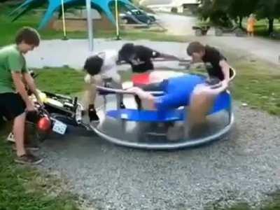 guys speeding up a whirl spinner with the help of a motorcycle