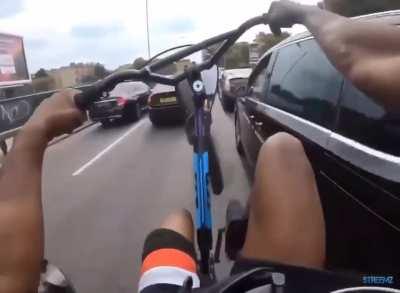 Doing wheelies on a busy road