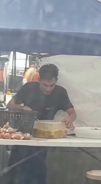 Food handler is spitting in the food he prepared. Is it normal? 