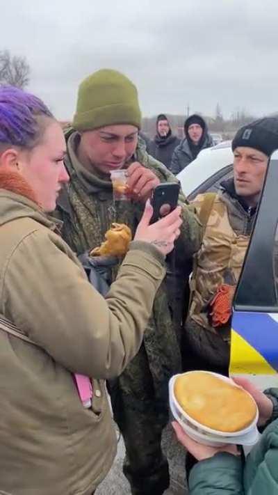Ukrainians tending to the need of a Russian soldier who surrendered.