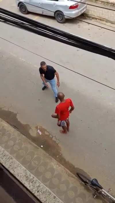 Two men lose their temper and fight in the middle of the street.