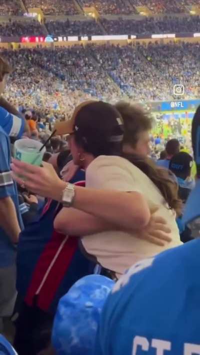 Fan wearing Detroit Pistons jersey to NFL game receives a Lions jersey from fellow fan