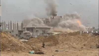 Israeli soldier is startled by an explosion of a nearby building, this week.