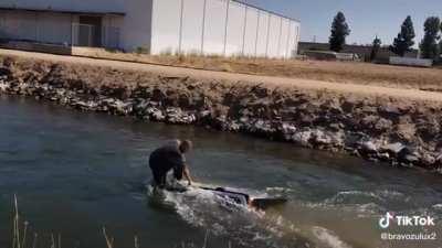 Guy floats down a creek on the roof of an SUV that he apparently just purchased a week prior