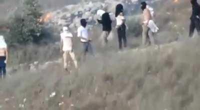 Illegal Jewish settlers with the presence & protection of the Israeli army set fire to Palestinian agricultural field as they also throw stones at the Palestinians