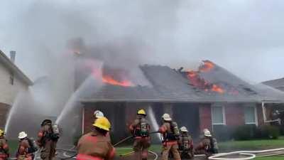 Firefighters battle a raging house fire during Hurricane Ida