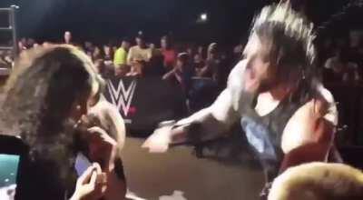 Roman Reigns checks on a fan after beating up Corbin a little too close to them