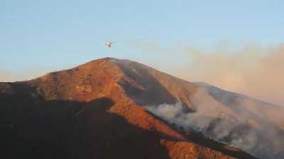 Insane sight. DC-10 AirTanker steep decent into a canyon to form a fire line in California!!!