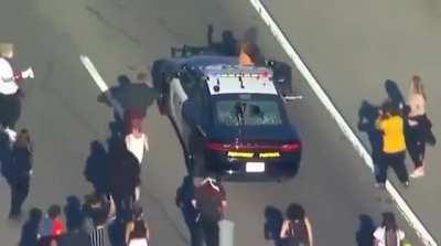 Protester knocked out after riding on top of Police car at LA protests