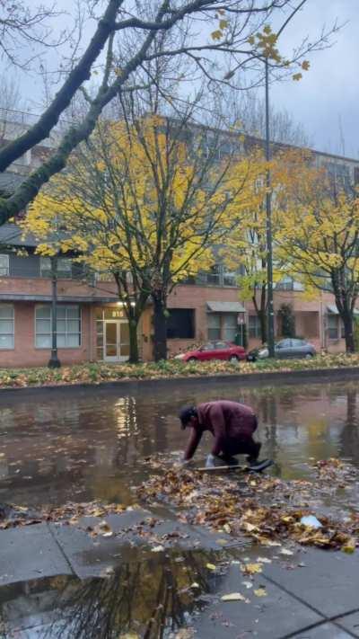 Clearing a blocked storm drain that flooded a busy street.