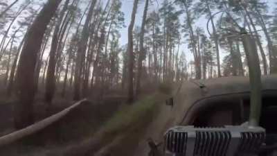 Archival GoPro footage of Colombian soldiers in Ukraine's International Legion evacuating a wounded soldier on a pick-up truck in the Serebryansky Forest while under artillery shelling