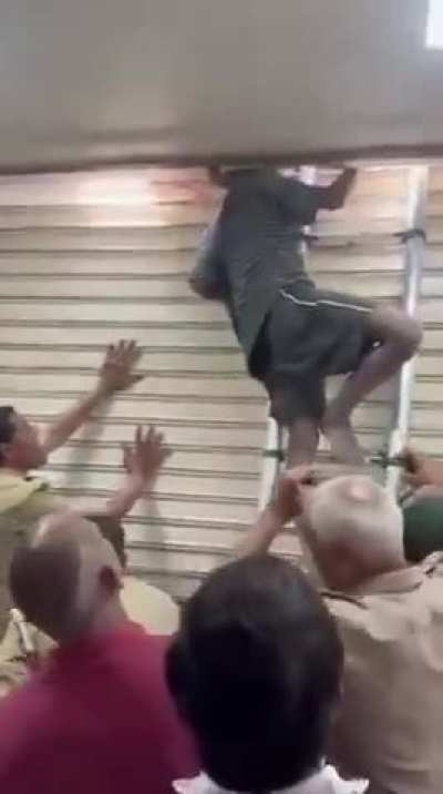 📍GHAZIABAD , UTTAR PRADESH | Thief got his neck stuck in a clinic's metal rolling shutter during a break-in attempt and remained trapped until afternoon , Firefighters rescued him using a ladder later
