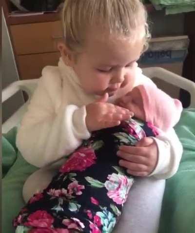 3-year old girl meets her baby sister for the first time.