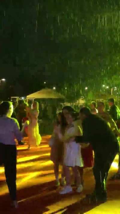 Kosovo’s President and her family join U.S. embassy staff to perform a choreographed dance in heavy rain, celebrating the U.S. Independence Day