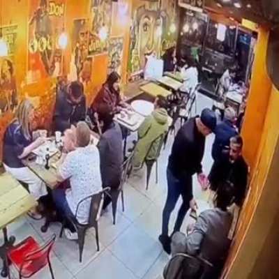 A thief in Soho, London, distracts customers by covering their phones with a piece of paper before stealing them.