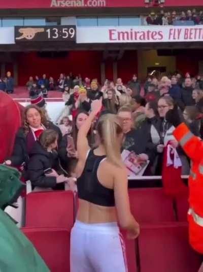 Leah giving her shirt to a fan