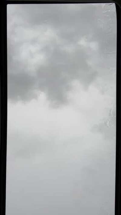 Sitting in the car in a parking lot, watching the rain fall on the sunroof