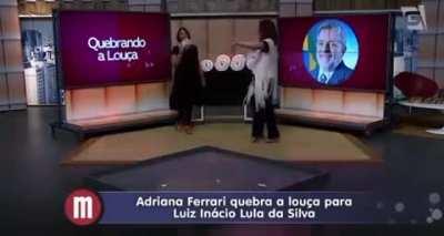 A outra tentando quebrar um prato com a foto do Lula no programa da Catia Fonseca