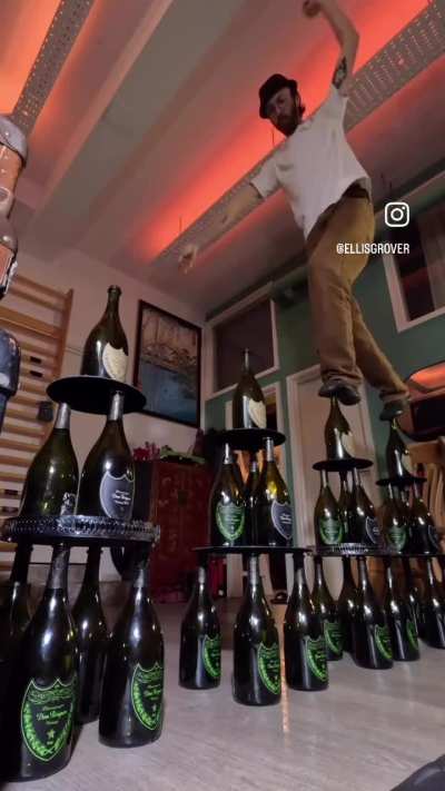 Walking on champagne bottles stacked 3 levels high