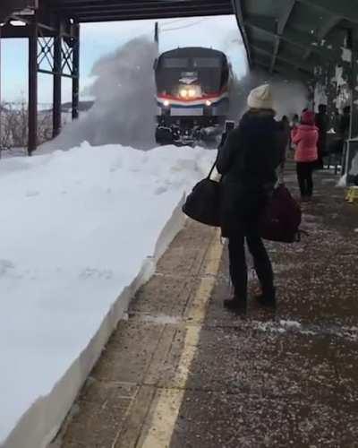 Standing near track while train passing through snowy track