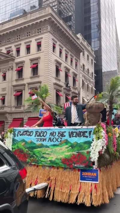 AOC and NYC mayoral candidate Zohran Mamdani dancing on a float
