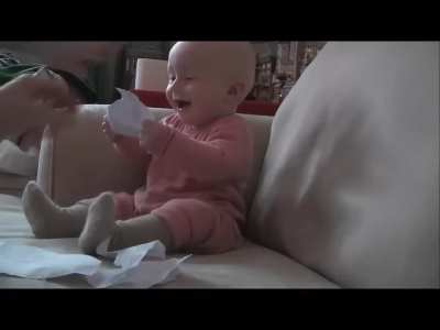 Baby laughing at ripping paper