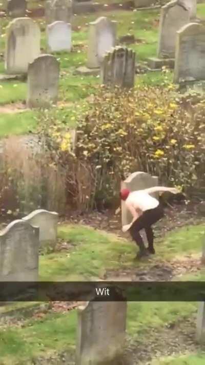 A lone woman getting groovy in a cemetery.