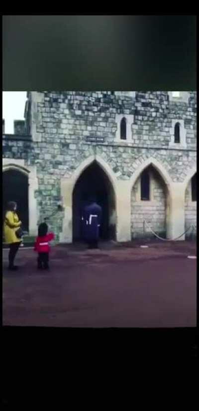 Small child dresses up as one of the queens guards.