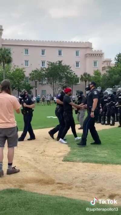 Police arresting a peaceful protestor for simply speaking to them.