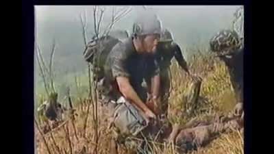 US and ARVN forces have a close range grenade exchange with NVA soldiers in a fortified position and kill several of them. Friendly casualties are treated.