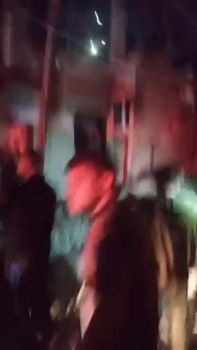 Destruction seen all around a Palestinian neighborhood after Israeli shelling. Healthcare workers carry the bodies of victims out of the rubble.