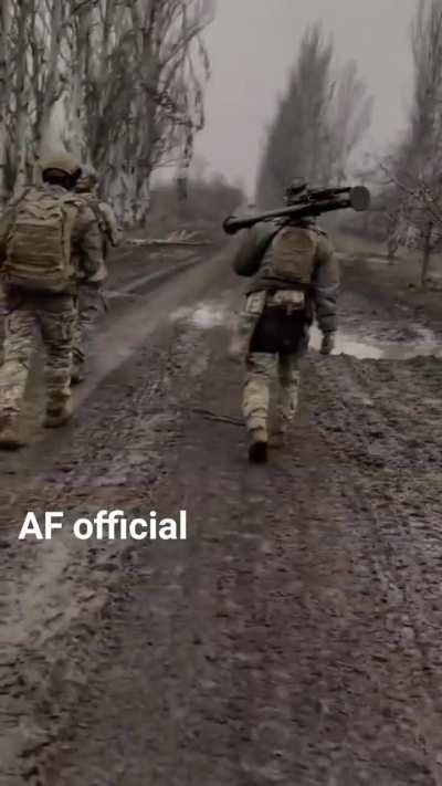 Ukrainian troops march along a muddy road with FIM-92 Stinger MANPADS at the ready.