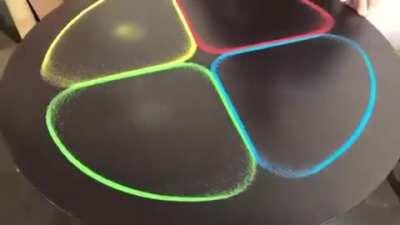 The sounds of Japanese artist Kenichi Kanazawa manipulating sand on a steel tabletop.